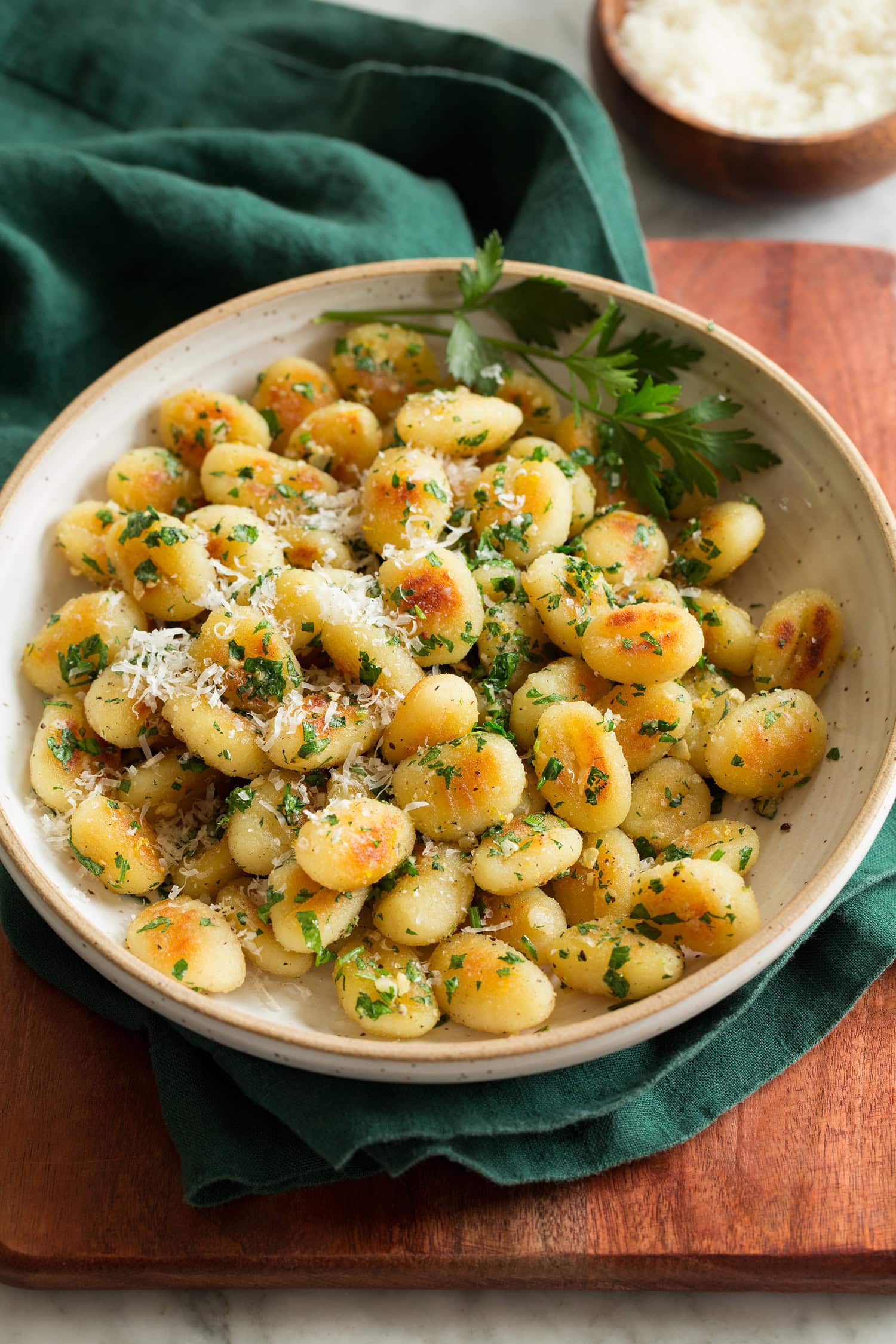 Pan Fried Gnocchi Pan fried gnocchi shown with parmesan and parsley garnish.