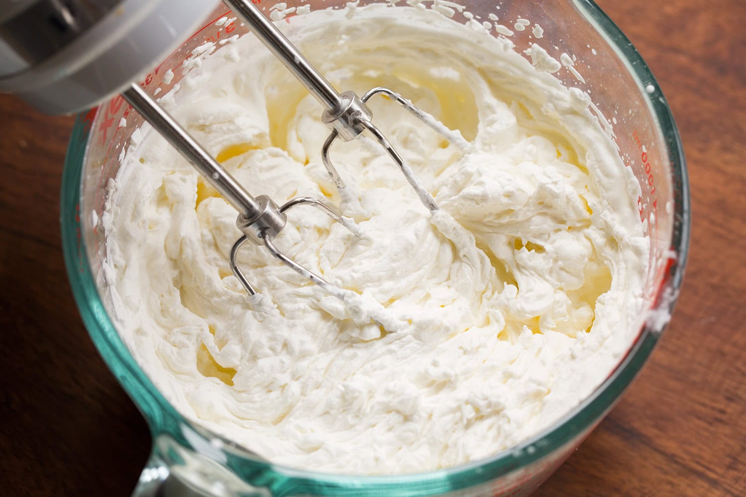 Strawberry Cheesecake Tiramisu Whipped cream in a glass measuring cup.