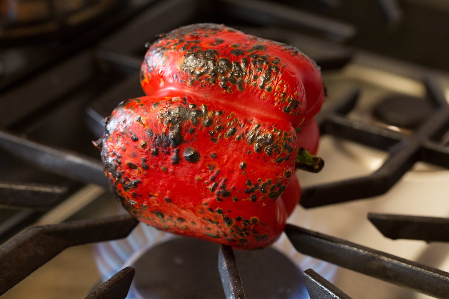 Tuna Pasta Salad A bell pepper being roasted over a gas stove flame.