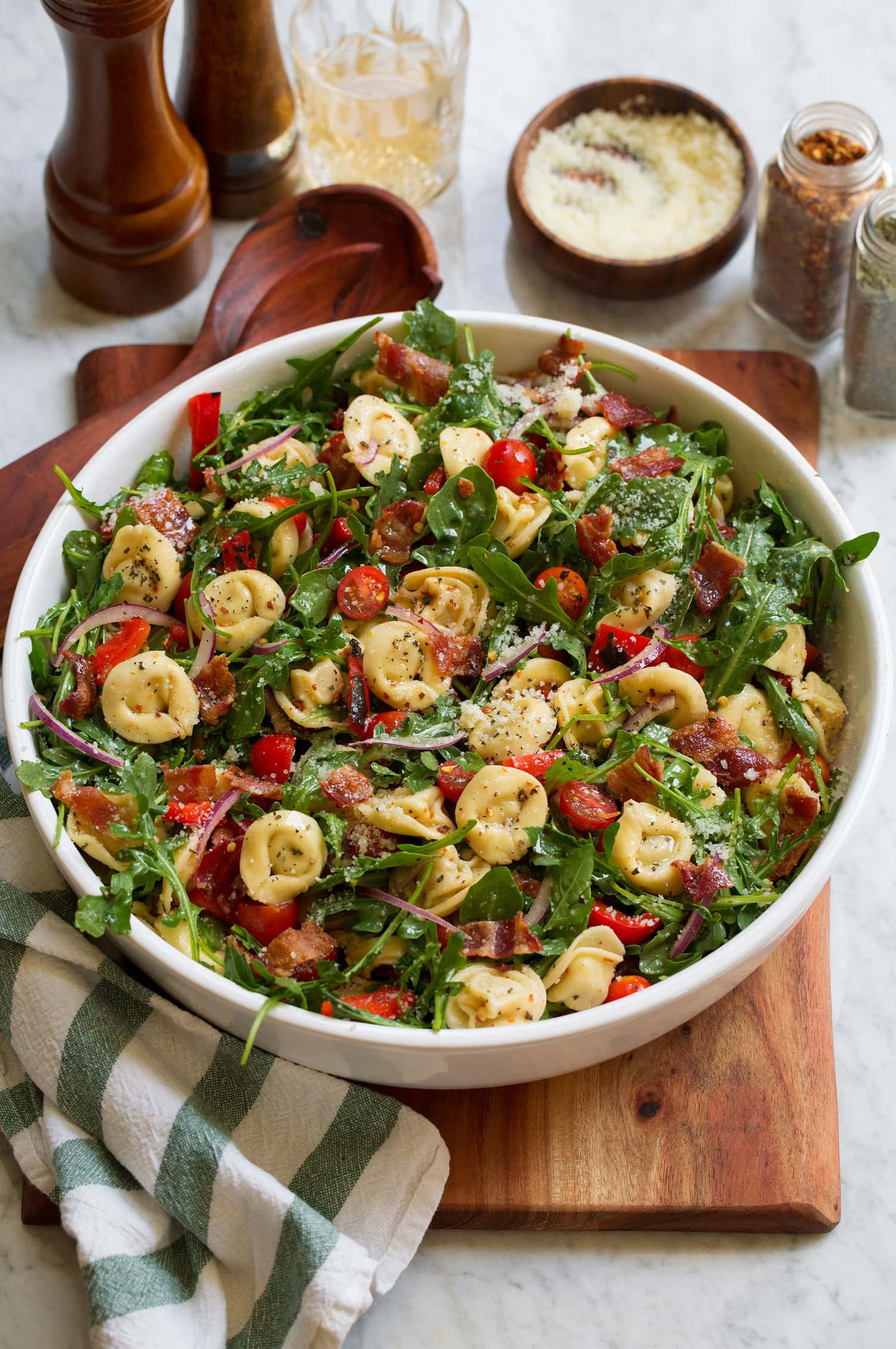 Tortellini Pasta Salad Tortellini pasta salad with four cheese tortellini, arugula, bacon, tomatoes and bell peppers.