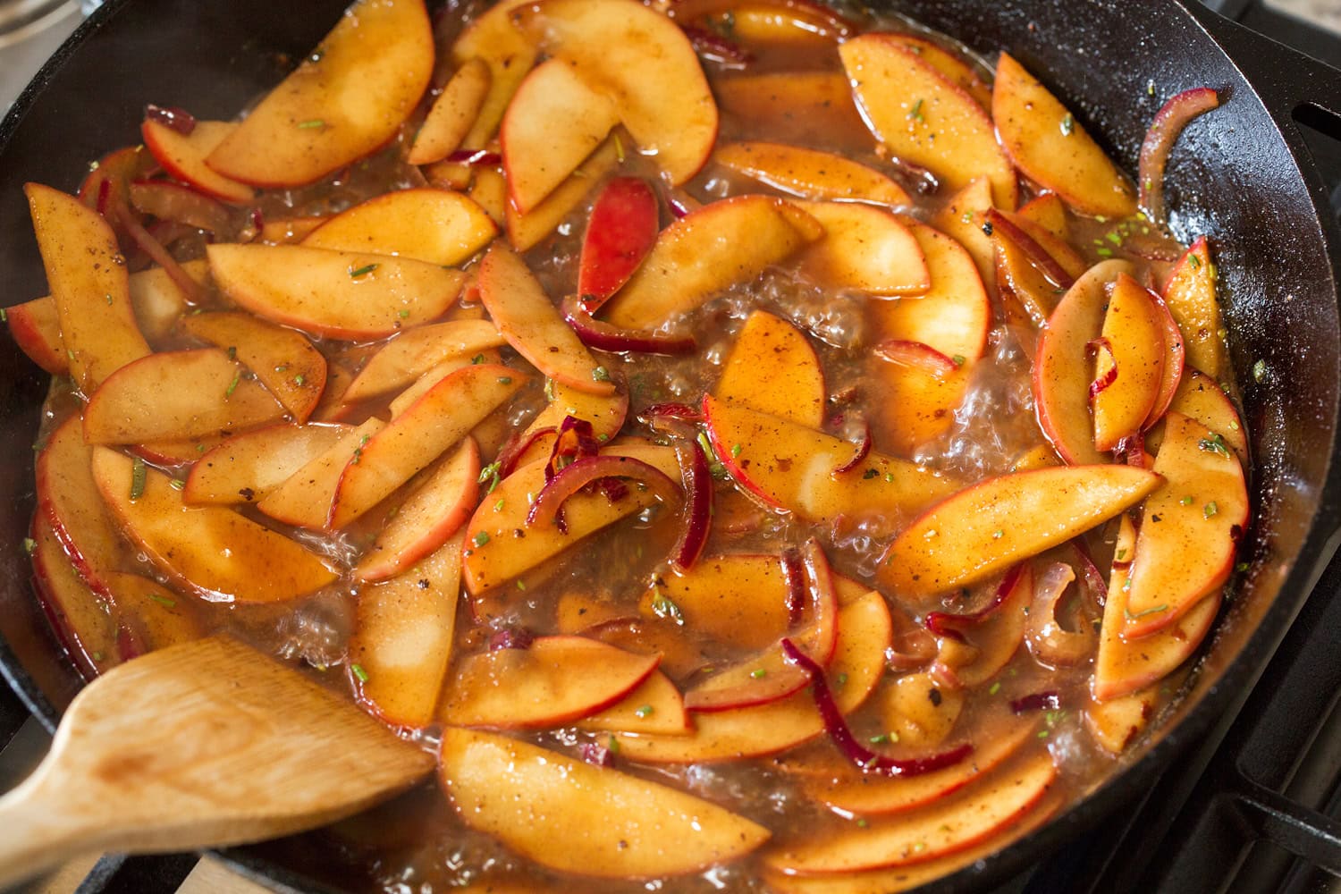 Apple Chicken Apples simmering in pan sauce to soften.
