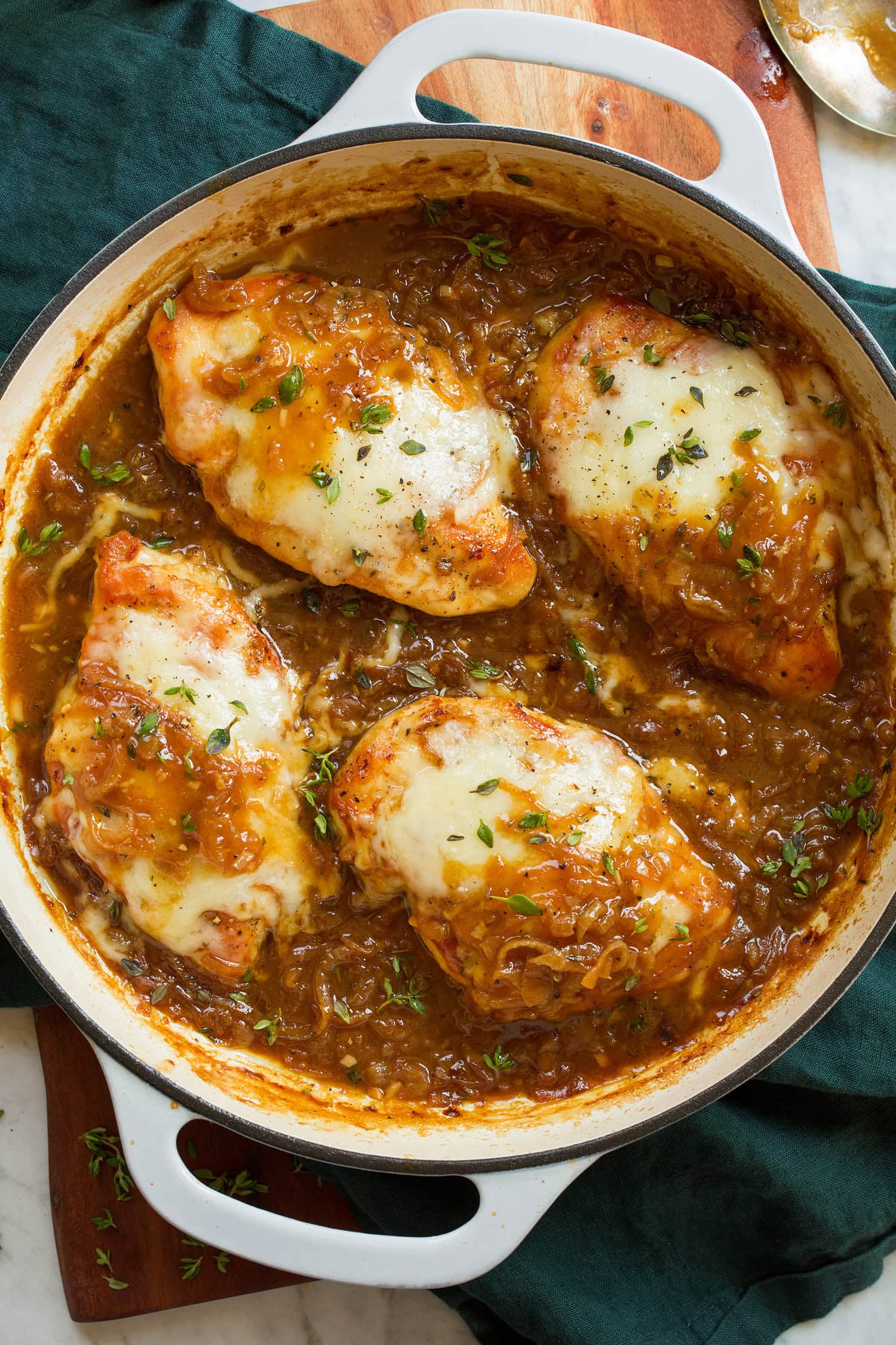French Onion Chicken Four pieces of French onion chicken with Swiss cheese and herbs in a skillet.