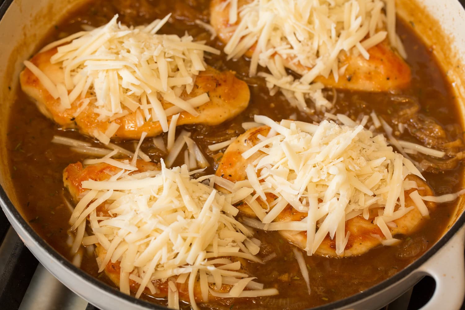 French Onion Chicken Grated cheese on chicken breasts before melting.