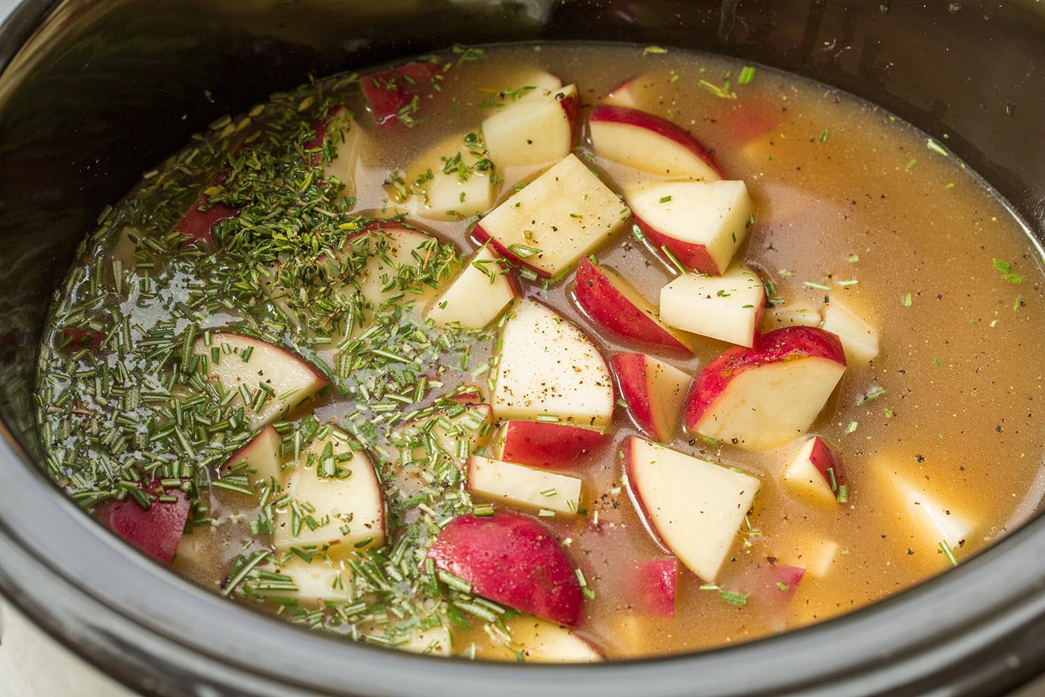 Slow Cooker Ground Beef Stew Potatoes, broth and herbs in a slow cooker.