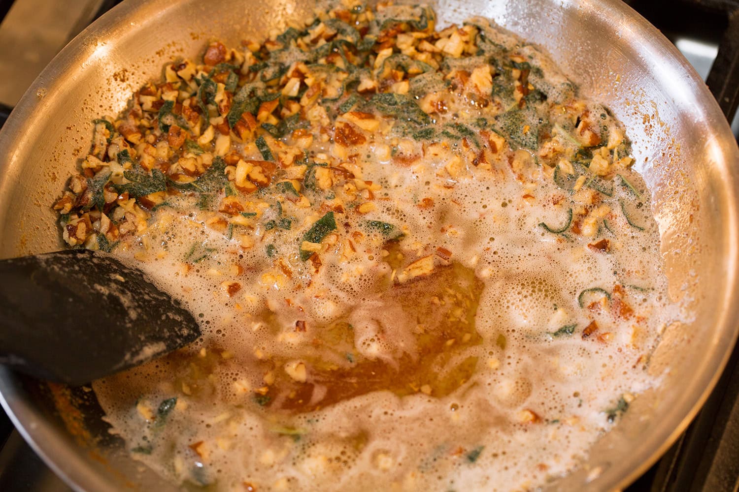 Browned butter sage sauce in a stainless steel skillet on the stovetop shown completed.