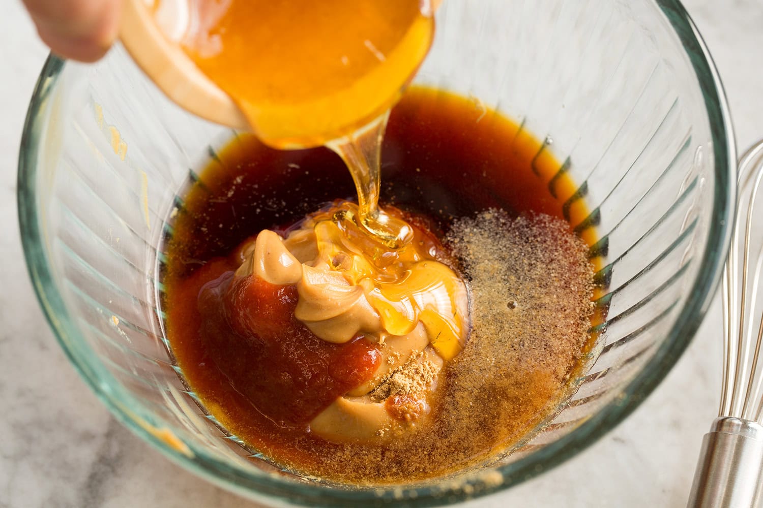 Chicken Protein Bowl Honey being added to peanut sauce.