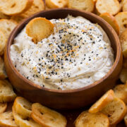 Everything bagel dip shown with homemade bagel chips on a platter.