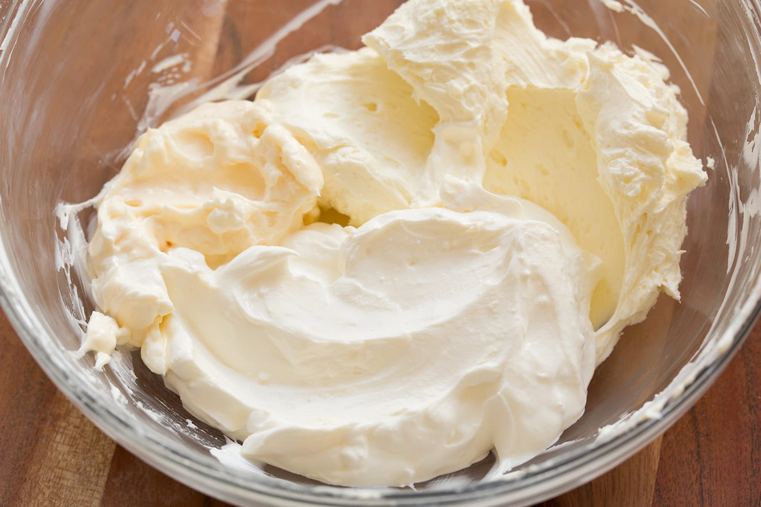Whipped cream cheese, mayonnaise, and sour cream in glass mixing bowl.