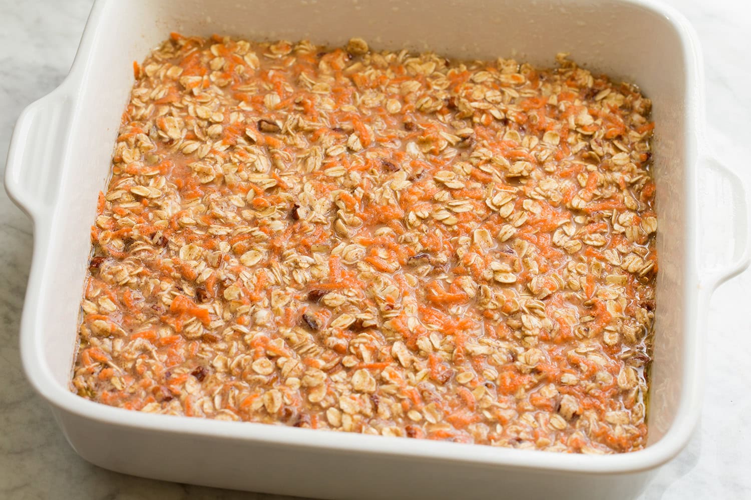 Raw carrot cake baked oatmeal in baking dish.