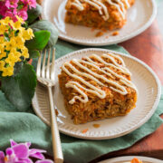 Two slices of carrot cake baked oatmeal covered in a cream cheese icing.
