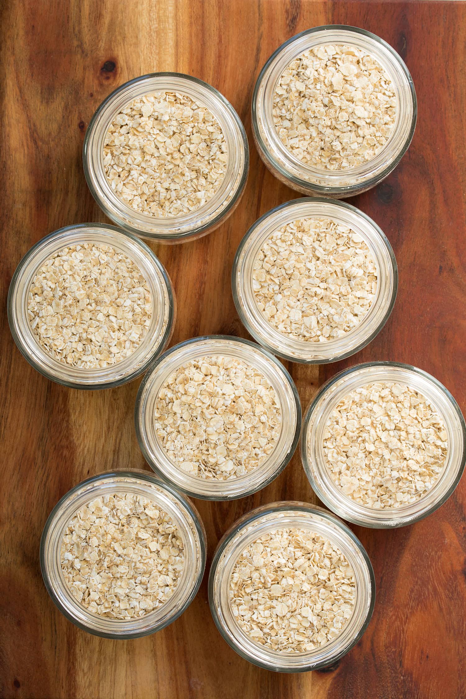 Quick oats added to eight separate glass jars.