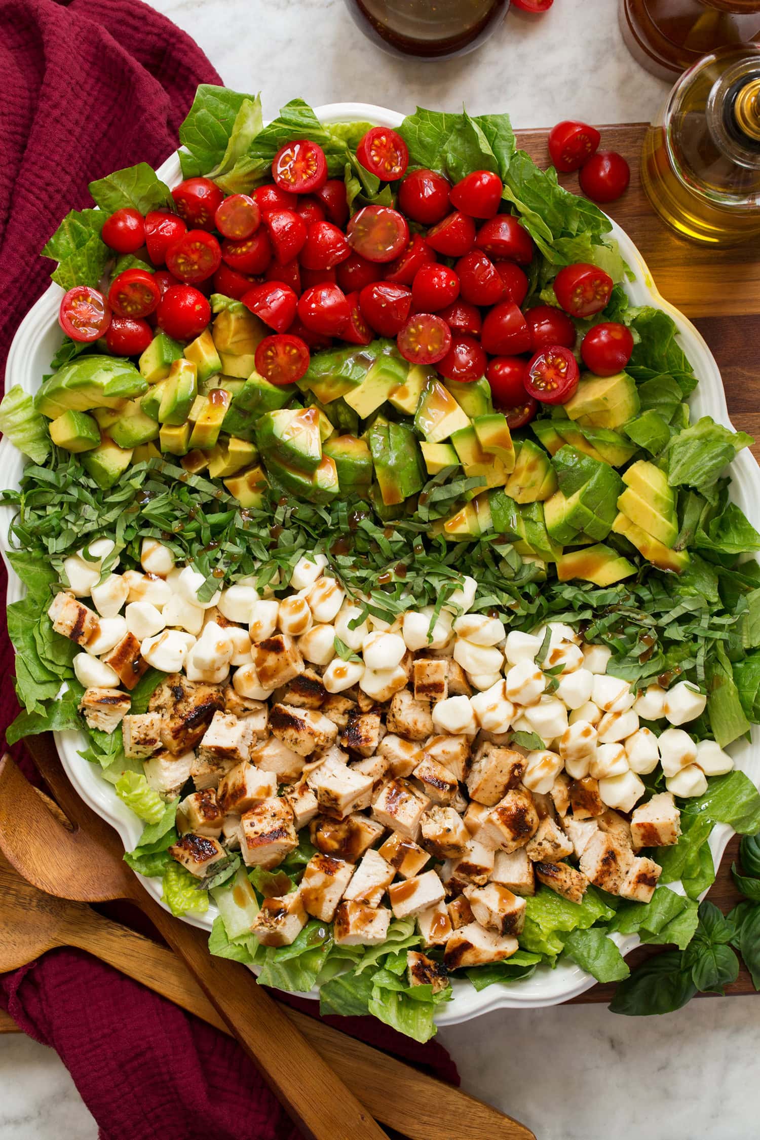 Caprese chopped salad with grilled chicken, avocado, tomato, fresh mozzarella, and basil shown from overhead.