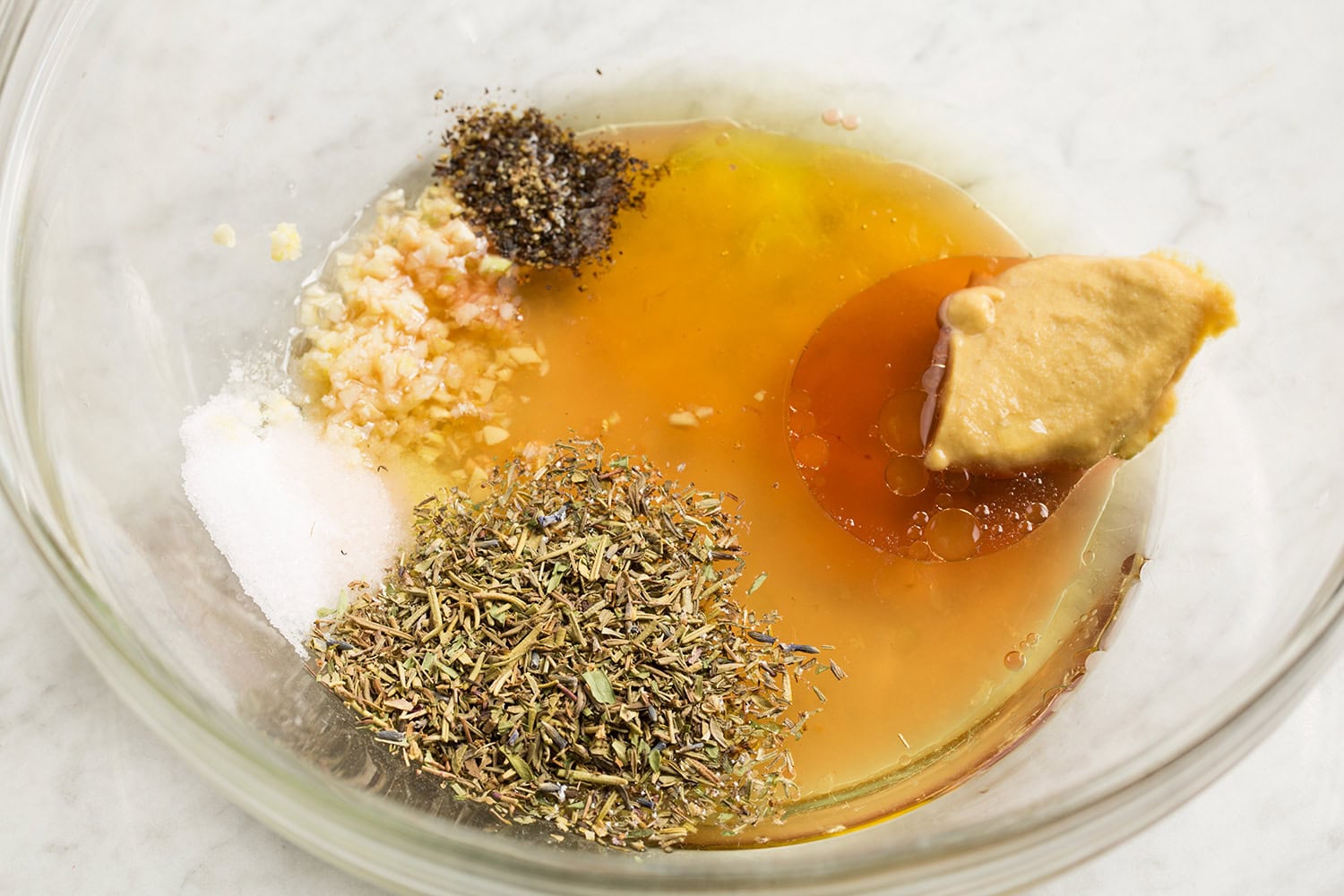 Chicken marinade ingredients in a glass mixing bowl shown before mixing.