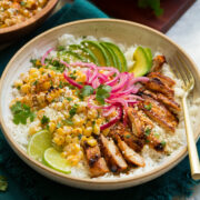 Street corn and chicken rice bowl with avocado and pickled red onions.