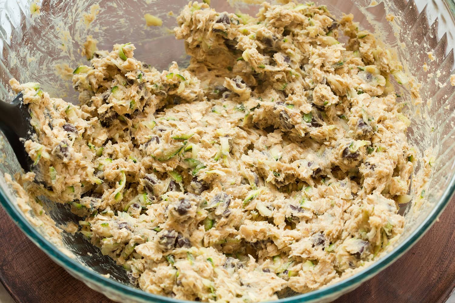 Completed zucchini oat chocolate chip cookie dough mixture shown in glass mixing bowl.